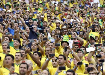 Spectators take photos of their national teams before the group A World Cup soccer match between Cameroon and Brazil at the Estadio Nacional in Brasilia, Brazil, Monday, June 23, 2014. (AP Photo/Natacha Pisarenko)