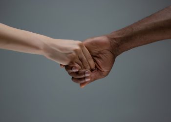 Racial tolerance. Respect social unity. African and caucasian hands gesturing isolated on gray studio background. Human rights, friendship, intenational unity concept. Interracial unity all around the world.