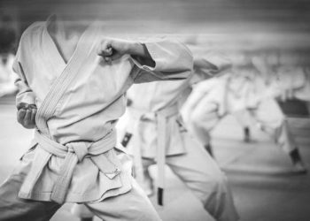 Elbow punch in karate. Children's training. Black and white photo with film grain effect.
