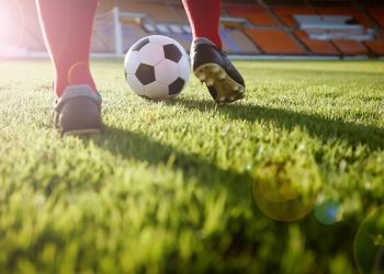 soccer or football player standing with ball on the field for Kick the soccer ball at football stadium